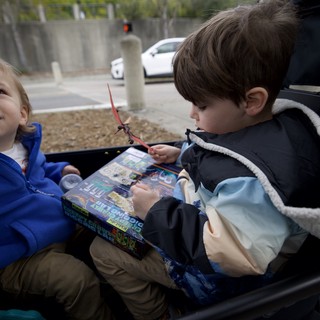 Brothers Reading Comics Together in Car Trunk