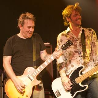 Two Men Jamming on Stage with Guitars