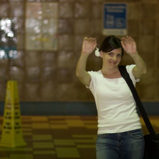 Playful Woman Raising Hands in Transit Station