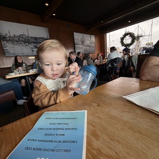 Young Child with Sippy Cup at Restaurant Table