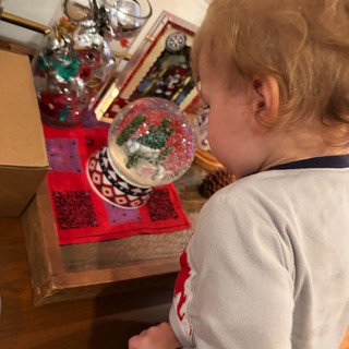 Child Admiring Snow Globe Collection at Bedside