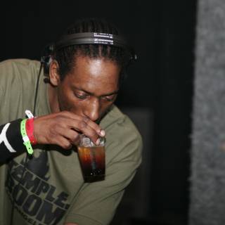 Dreadlocked man sipping from a glass