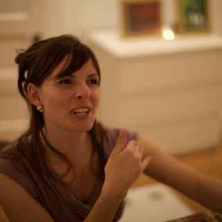 Penelope in Animated Conversation at Indoor Gathering