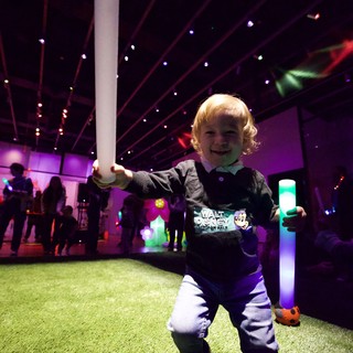 Young Child Enjoying Baby Rave with Glowing Foam Batons
