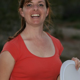 Laughing Woman in Red Top Holds Frisbee Outdoors