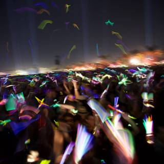 Partygoers Raise Their Hands Under Dazzling Lights