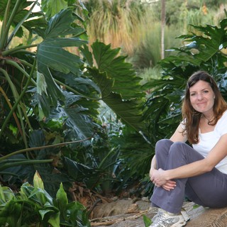 Woman Relaxing Among Lush Tropical Garden Foliage