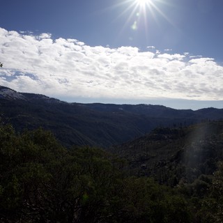 Sunburst Over Forested Mountain Valley in Winter