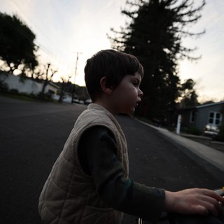 Young Boy Skateboarding at Dusk in Suburban Neighborhood