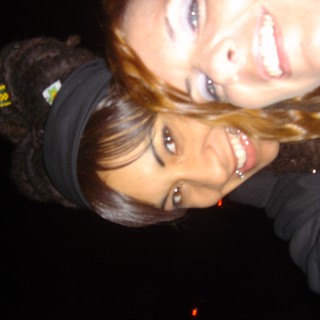 Two Friends Smiling Close Together at Night