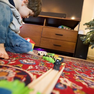 Child Playing with Wooden Train Set on Christmas