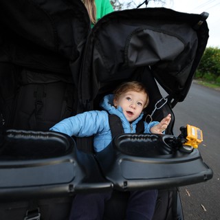 Curious Toddler's Wide-Eyed Wonder in Black Stroller