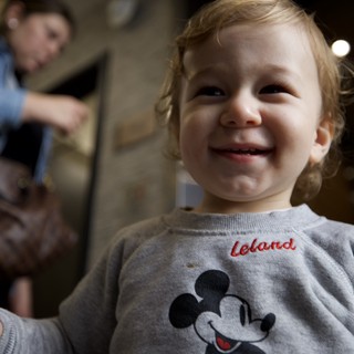 Joyful Toddler in Mickey Mouse Sweatshirt at Home