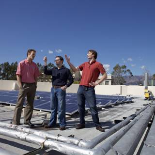 Three Men Install Solar Panels on a Rooftop