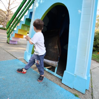 Child Exploring Colorful Rainbow Tunnel Slide at Playground
