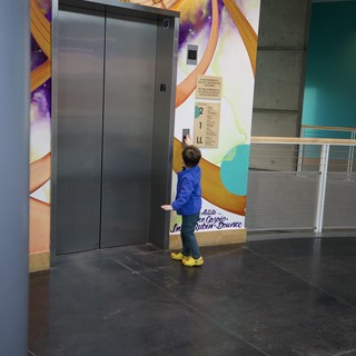 Child Exploring Interactive Elevator at Science Center