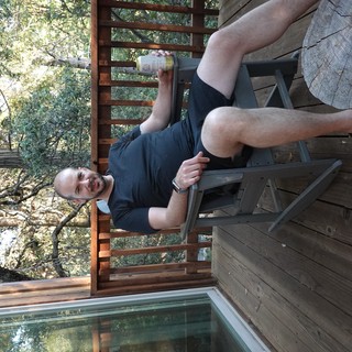 Man Relaxing on Wooden Deck Among Trees