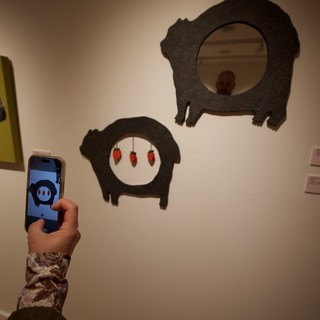 Visitor Photographing Pig Art Installation in Gallery