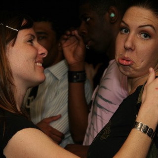 Two Women Share a Playful Moment at Nightclub