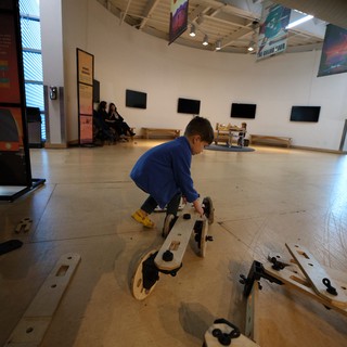 Child Playing with Wooden Construction Toy in Museum Gallery