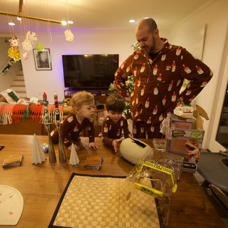 Father and Children in Matching Pajamas at Christmas Table