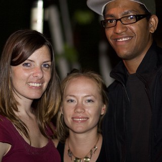 Three Friends Smiling Together at Night Event