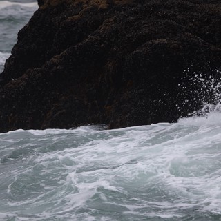 Furious Waves Crash Against Dark Coastal Rock
