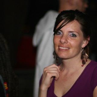 Smiling Woman in Purple at Evening Social Event