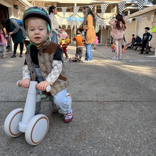 Young Child on Balance Bike at Neighborhood Party