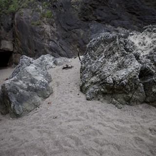 Dark Coastal Cliffs Frame Sandy Cove Passage