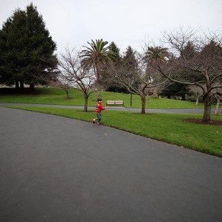 Child on Scooter in Park on Overcast Day