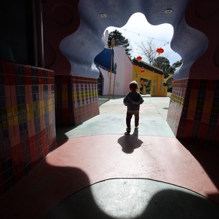 Child Approaching Whimsical Portal in Colorful Passage