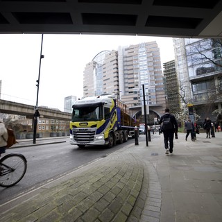 Heavy Truck Navigating Under Modern Urban Bridge