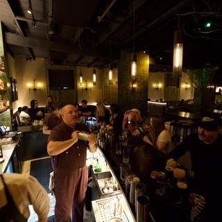 Bartender Mixing Craft Cocktails in Dimly Lit Modern Bar