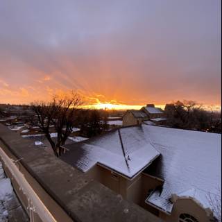 Sunset over a Snowy House Roof