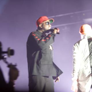 Two Men in Black Suits and Red Hats Perform on Stage