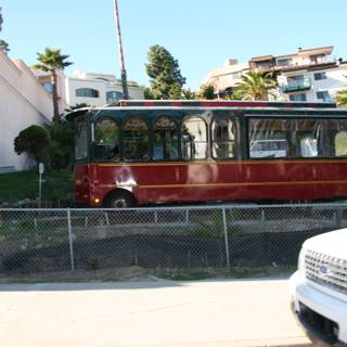 Red and White Trolley Car Parked on the Side of the Road
