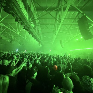 Massive Crowd Under Green Laser Light Show at Electronic Music Concert
