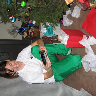 Joyful Woman Unwrapping Christmas Gifts by Tree