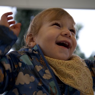 Joyful Toddler Laughing Under Outdoor Porch Ceiling