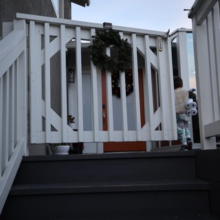 Child on Winter Deck with Holiday Wreath