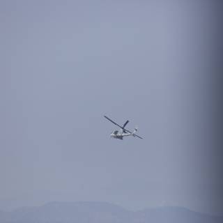 Helicopter Soaring Over Mountain Range
