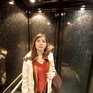 Woman Makes Funny Face in Dark Elevator