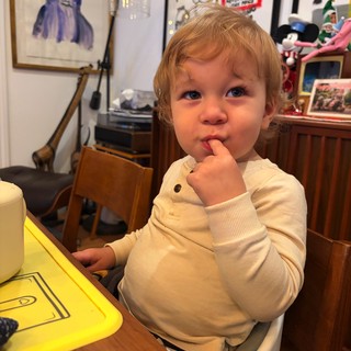 Toddler with Finger in Mouth at Home Table