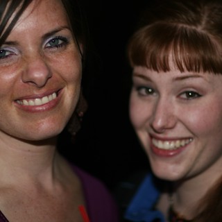 Two Smiling Women Posing Together at Night Event