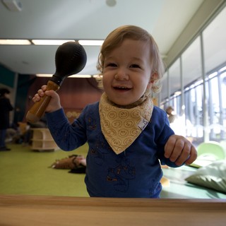 Joyful Toddler Playing with Wooden Hammer Toy