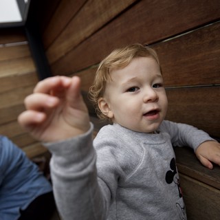 Curious Toddler Reaching Up on Wooden Stairs
