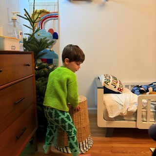 Child in Green Dinosaur Pajamas Standing in Bedroom