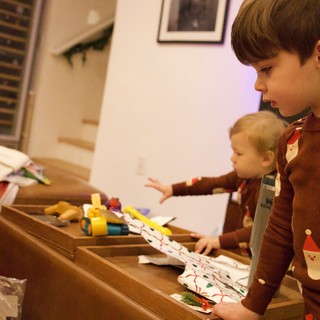 Brothers Unwrapping Christmas Presents Together at Home
