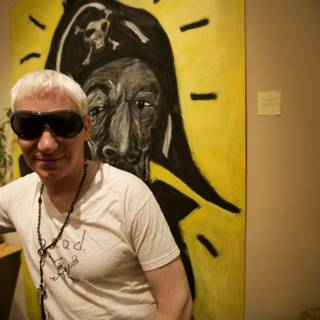 Man in Sunglasses Poses in Front of Artwork